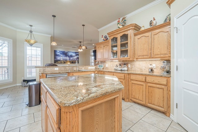 kitchen with decorative light fixtures, ornamental molding, and a kitchen island