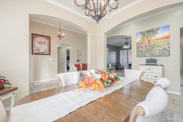 tiled dining area featuring ornamental molding and ceiling fan with notable chandelier