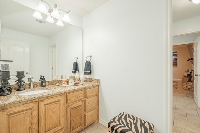 bathroom with vanity, a chandelier, and tile patterned flooring