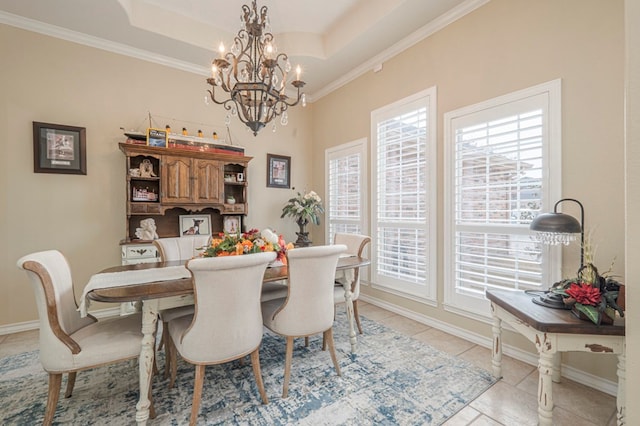 tiled dining area featuring an inviting chandelier, ornamental molding, and a tray ceiling