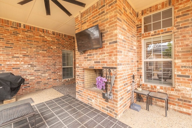 view of patio featuring an outdoor brick fireplace and a grill