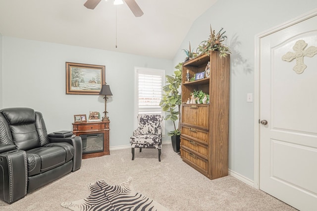 living area featuring lofted ceiling, light colored carpet, and ceiling fan