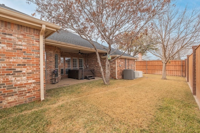 view of yard with ceiling fan, a hot tub, a patio, and central air condition unit