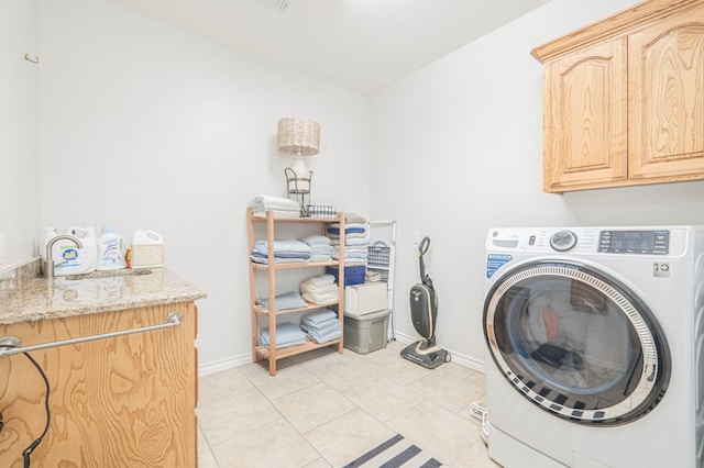 clothes washing area featuring cabinets, washer / dryer, sink, and light tile patterned floors