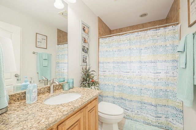 bathroom with vanity, walk in shower, and toilet