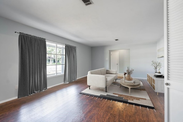 living area featuring dark wood-style floors, visible vents, and baseboards