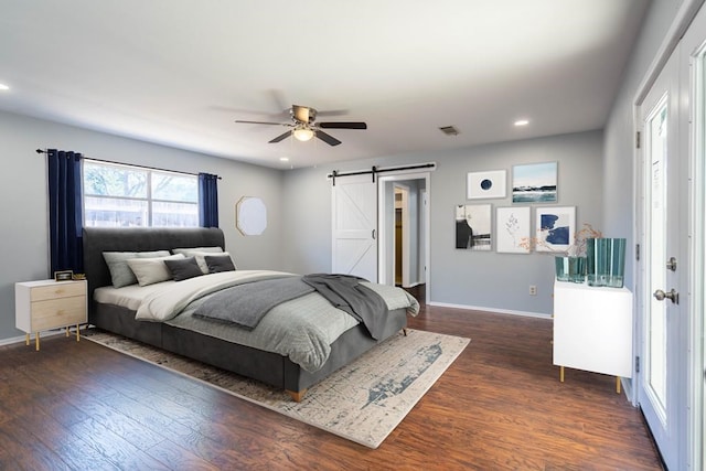 bedroom with a barn door, baseboards, visible vents, dark wood-style flooring, and recessed lighting