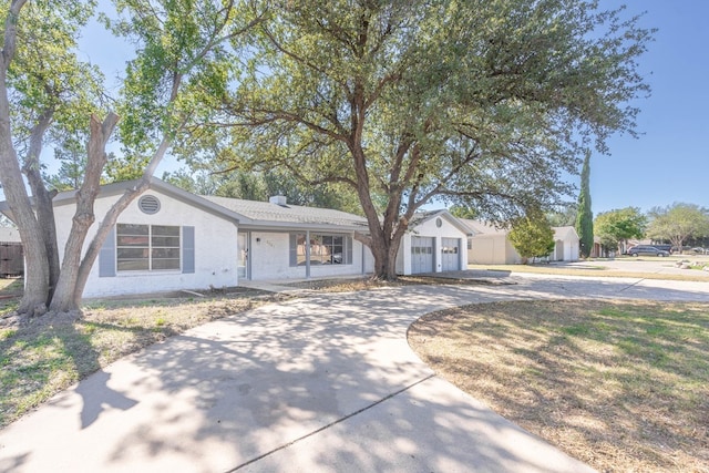 ranch-style home featuring concrete driveway