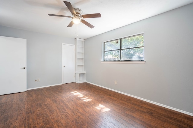 unfurnished bedroom with ceiling fan, baseboards, and dark wood finished floors