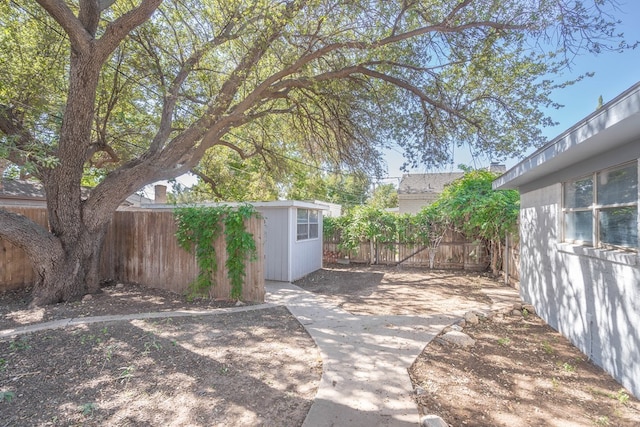 view of patio featuring an outbuilding, a fenced backyard, and a shed