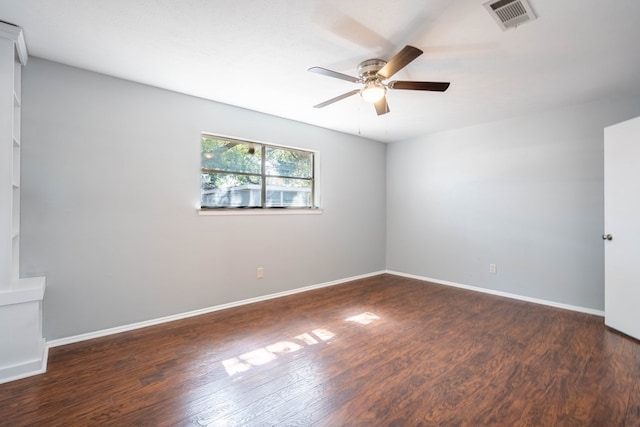 unfurnished room with dark wood-type flooring, visible vents, ceiling fan, and baseboards