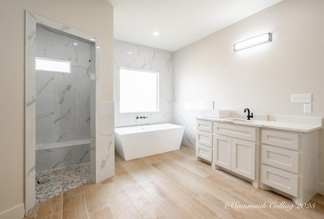 bathroom with vanity, hardwood / wood-style floors, shower with separate bathtub, and a healthy amount of sunlight