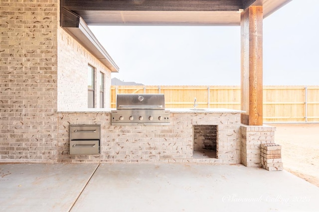 view of patio with an outdoor kitchen, a grill, and sink