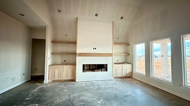 2815 S County Rd 1092, Midland, TX 79706 - unfurnished living room with concrete flooring, healthy amount of natural light, and a fireplace