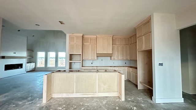 2815 S County Rd 1092, Midland, TX 79706 - kitchen with a kitchen island, unfinished concrete floors, light brown cabinets, a fireplace, and vaulted ceiling