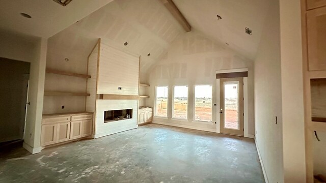 2815 S County Rd 1092, Midland, TX 79706 - unfurnished living room featuring unfinished concrete floors, a large fireplace, beamed ceiling, and high vaulted ceiling