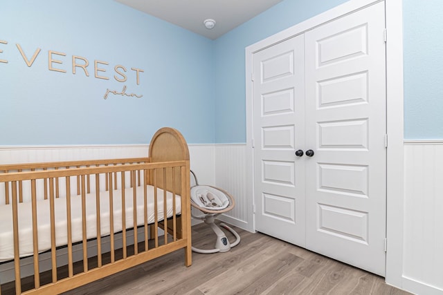 2013 Swenson St, Midland, TX 79705 - bedroom with a wainscoted wall, wood finished floors, a closet, and a nursery area