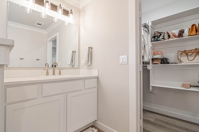 2013 Swenson St, Midland, TX 79705 - bathroom with vanity, wood finished floors, ornamental molding, a spacious closet, and baseboards