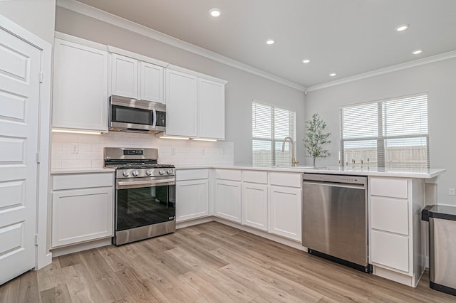 2013 Swenson St, Midland, TX 79705 - kitchen with appliances with stainless steel finishes, ornamental molding, decorative backsplash, light wood-style flooring, and recessed lighting