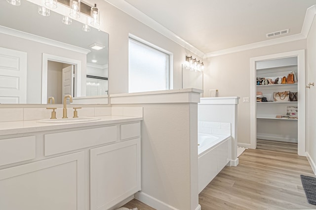 2013 Swenson St, Midland, TX 79705 - full bathroom with crown molding, wood finished floors, a garden tub, vanity, and a walk in closet