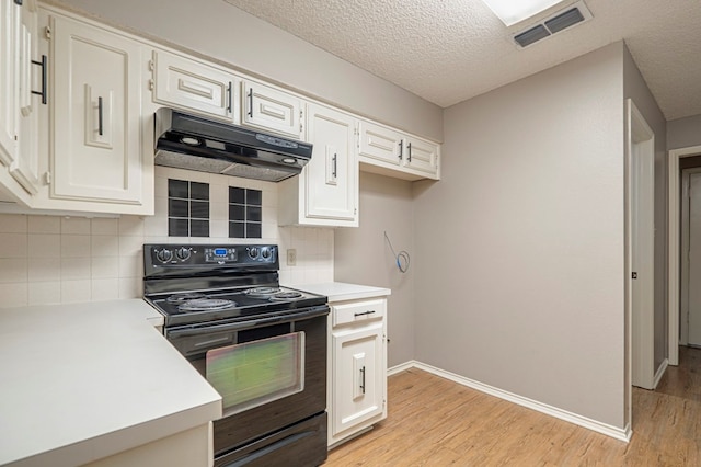 kitchen featuring backsplash, a textured ceiling, black electric range, light hardwood / wood-style floors, and white cabinetry