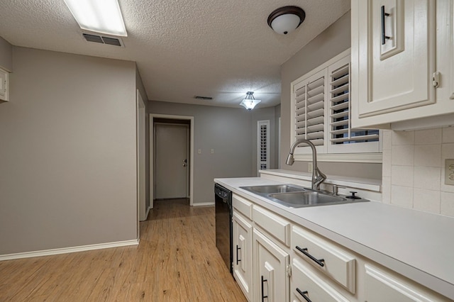 kitchen with dishwasher, sink, light hardwood / wood-style flooring, a textured ceiling, and white cabinets