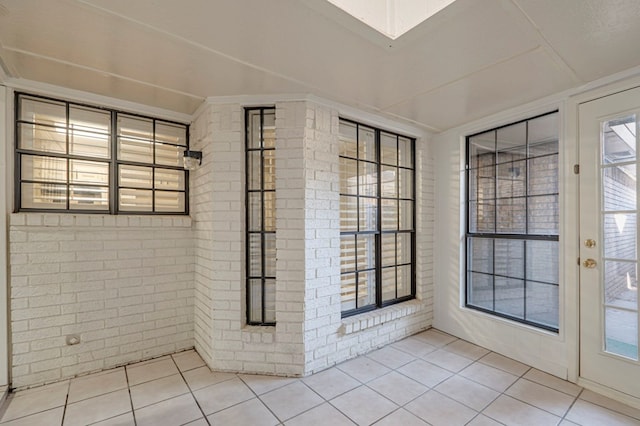 interior space featuring tile patterned floors and brick wall