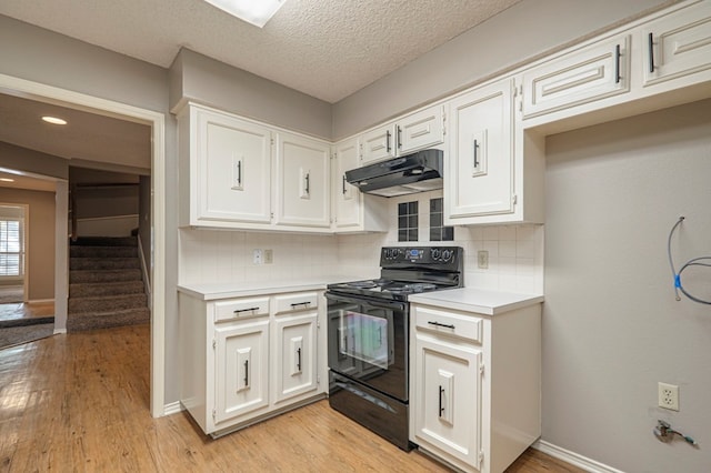 kitchen featuring backsplash, a textured ceiling, light hardwood / wood-style flooring, white cabinets, and black range with electric stovetop