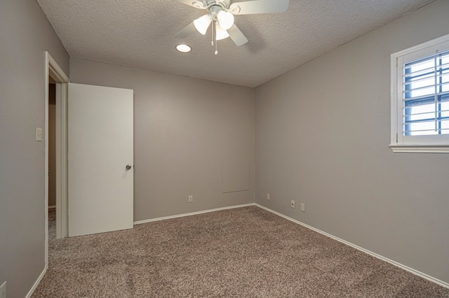 empty room featuring a textured ceiling, carpet floors, and ceiling fan