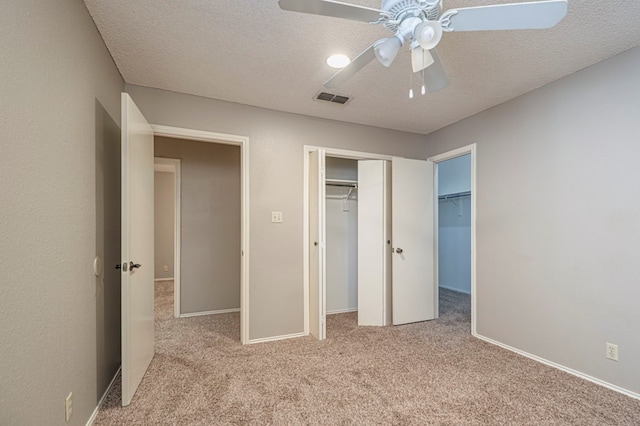 unfurnished bedroom with light carpet, a textured ceiling, and ceiling fan