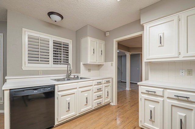 kitchen featuring dishwasher, sink, tasteful backsplash, white cabinets, and light wood-type flooring