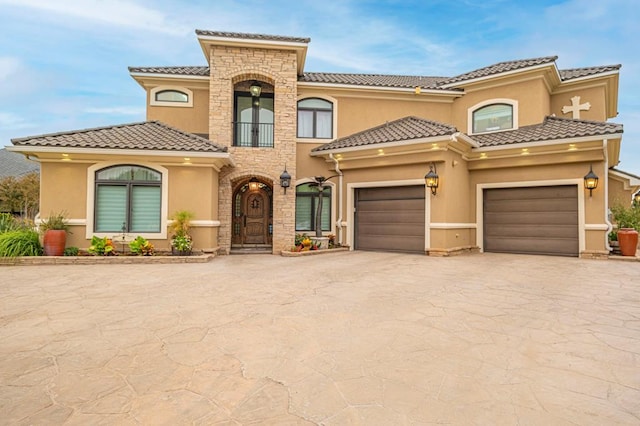 mediterranean / spanish house featuring a balcony, stucco siding, a tiled roof, and driveway