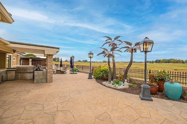 view of patio / terrace with an outdoor kitchen, fence, and a grill