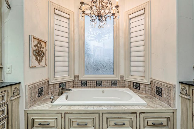 full bath with an inviting chandelier, tasteful backsplash, and a garden tub