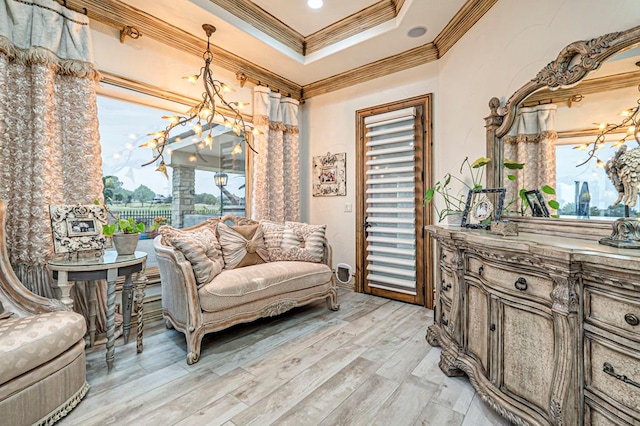 sitting room featuring plenty of natural light, ornamental molding, light wood-style flooring, and a raised ceiling
