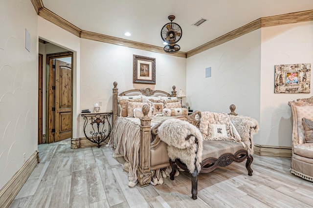 bedroom featuring crown molding, baseboards, light wood-type flooring, and visible vents