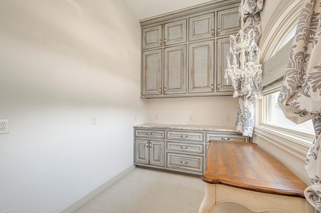 unfurnished office with baseboards and light colored carpet