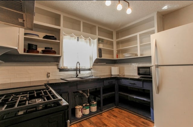 kitchen with a textured ceiling, sink, range, white fridge, and dark hardwood / wood-style floors