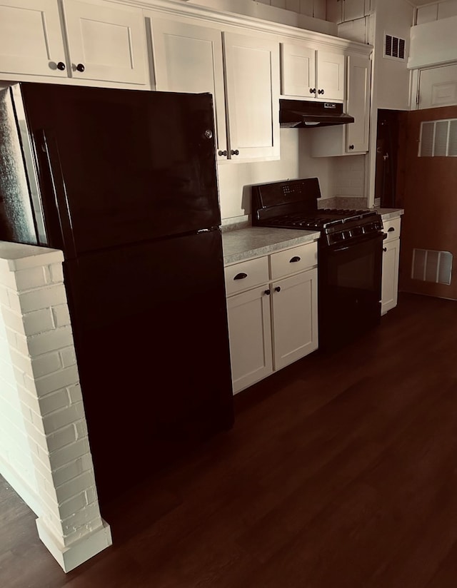 126 Coliseum Dr, Snyder, TX 79549 - kitchen with under cabinet range hood, visible vents, dark wood finished floors, and black appliances
