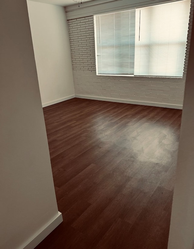 126 Coliseum Dr, Snyder, TX 79549 - unfurnished room featuring baseboards and dark wood-style flooring