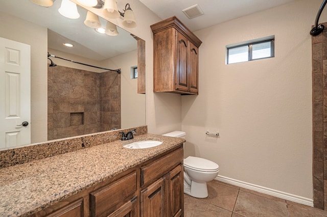 bathroom featuring toilet, tile patterned floors, walk in shower, and vanity