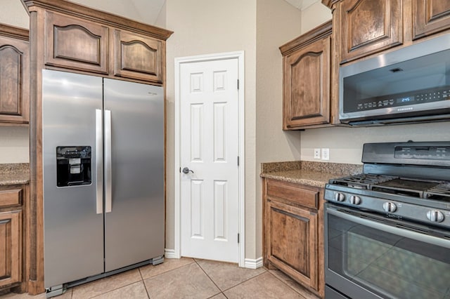 kitchen with stainless steel appliances and light tile patterned flooring