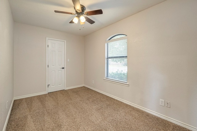 carpeted spare room featuring ceiling fan