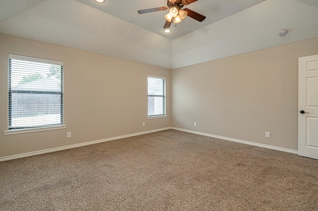 carpeted spare room with ceiling fan, a tray ceiling, and lofted ceiling