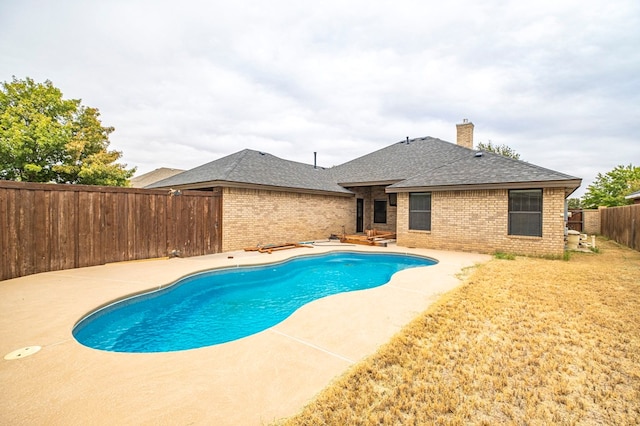 view of swimming pool featuring a patio area and a yard