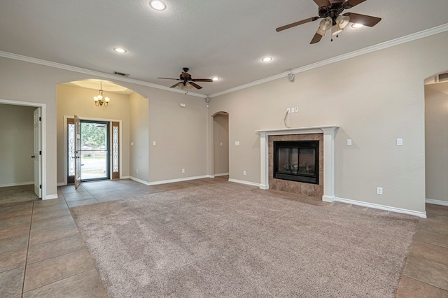 unfurnished living room featuring light tile patterned floors, a tiled fireplace, ceiling fan with notable chandelier, and crown molding