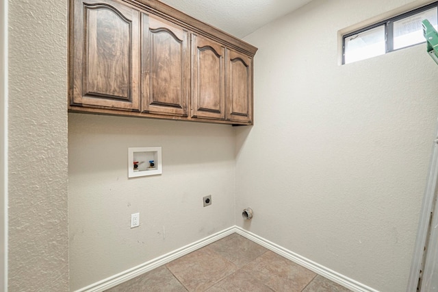 washroom featuring hookup for a washing machine, cabinets, hookup for an electric dryer, and light tile patterned flooring