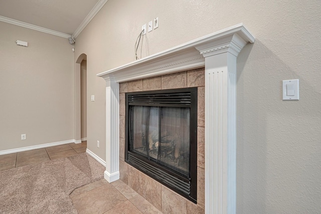 interior details featuring a tile fireplace and ornamental molding