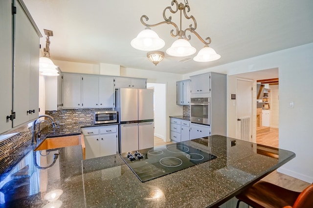 3000 Sentinel Ave, Midland, TX 79701 - kitchen with appliances with stainless steel finishes, backsplash, a peninsula, and pendant lighting