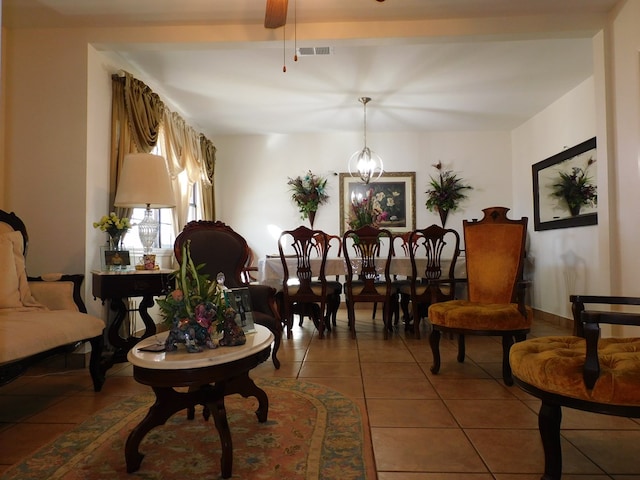 living area featuring ceiling fan with notable chandelier and tile patterned floors